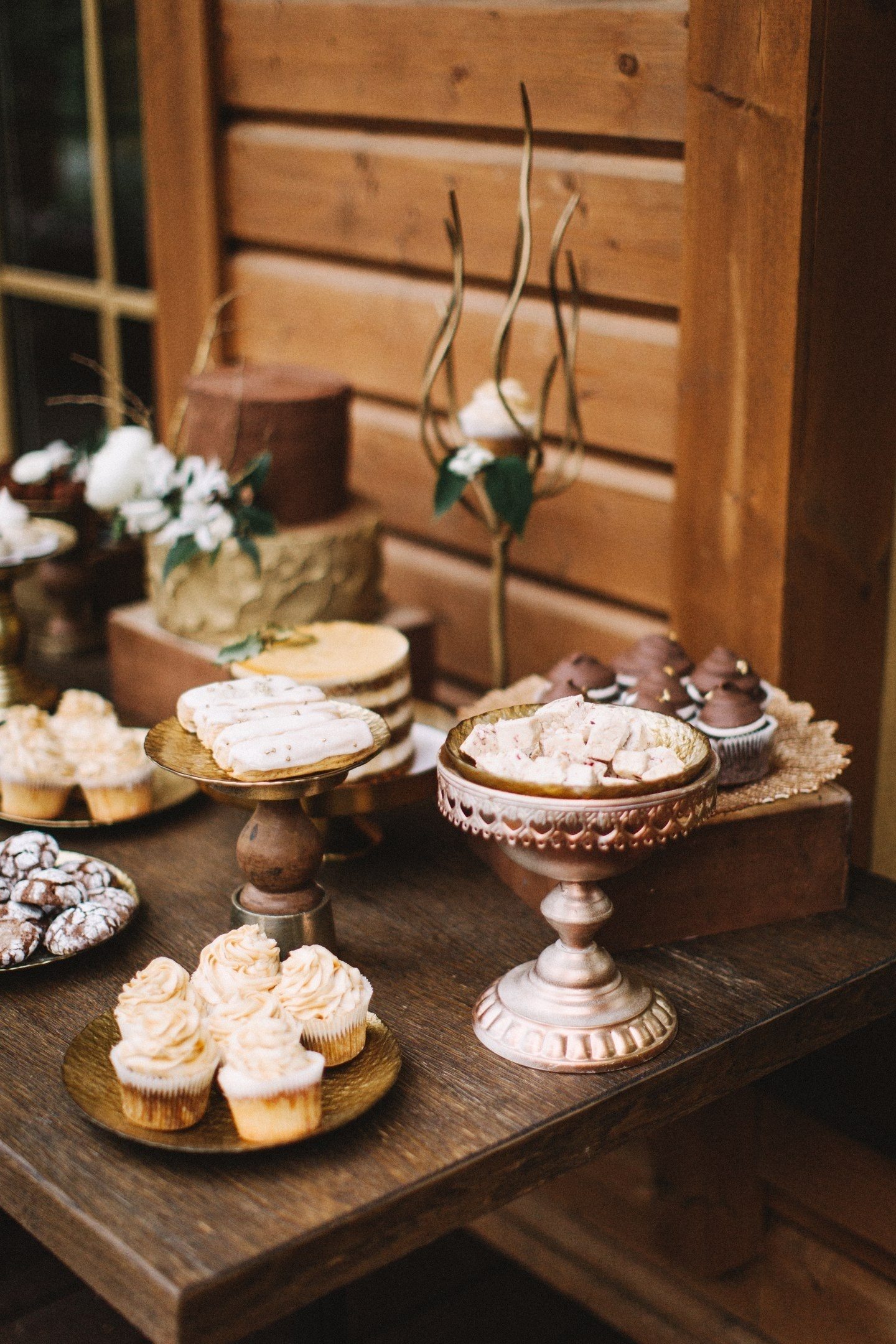 Rozbité tyče čokolády, lanýže, moka vzdušné dezerty, zdobené kávová zrna a prolamované sušenky s polevou ve stylu svatby vypadají skvěle ve společnosti starých krabic a ozdobených stojanů
